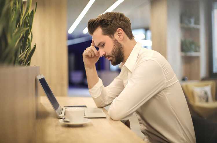 Canva Man With Hand On Temple Looking At Laptop (3)